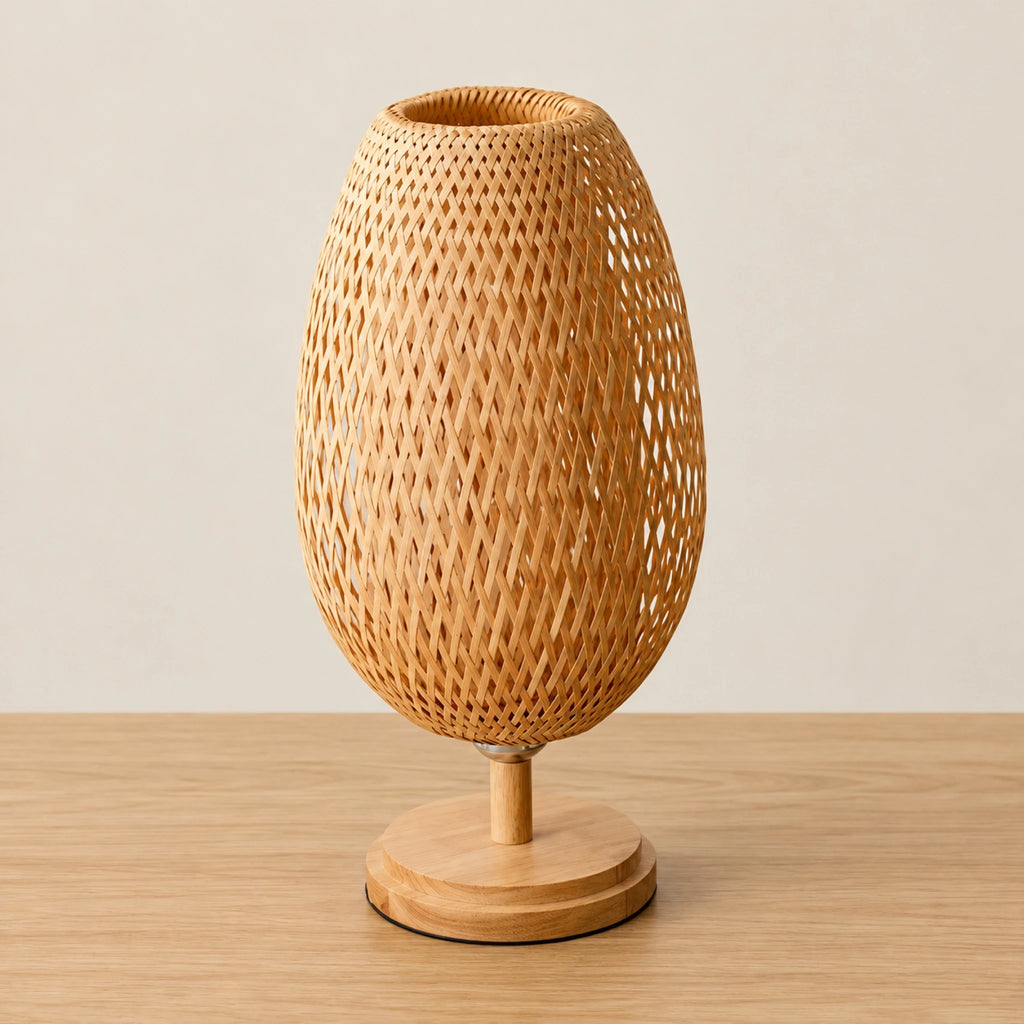 Lampe en bambou tressé éteinte, abat-jour ovale et pied en bois