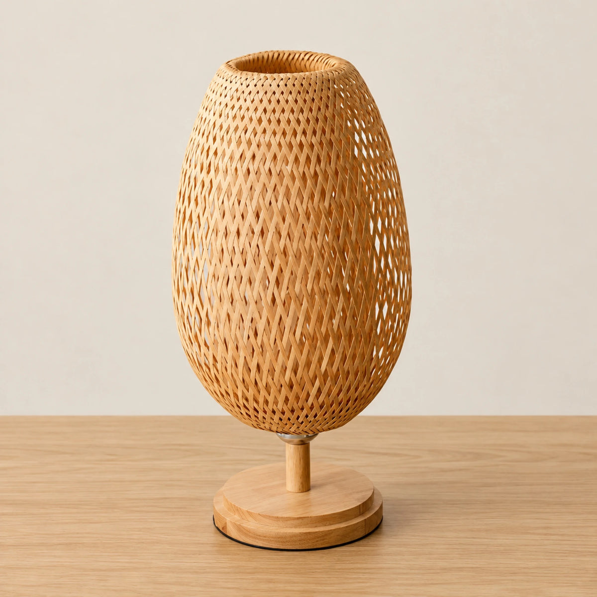 Lampe en bambou tressé éteinte, abat-jour ovale et pied en bois